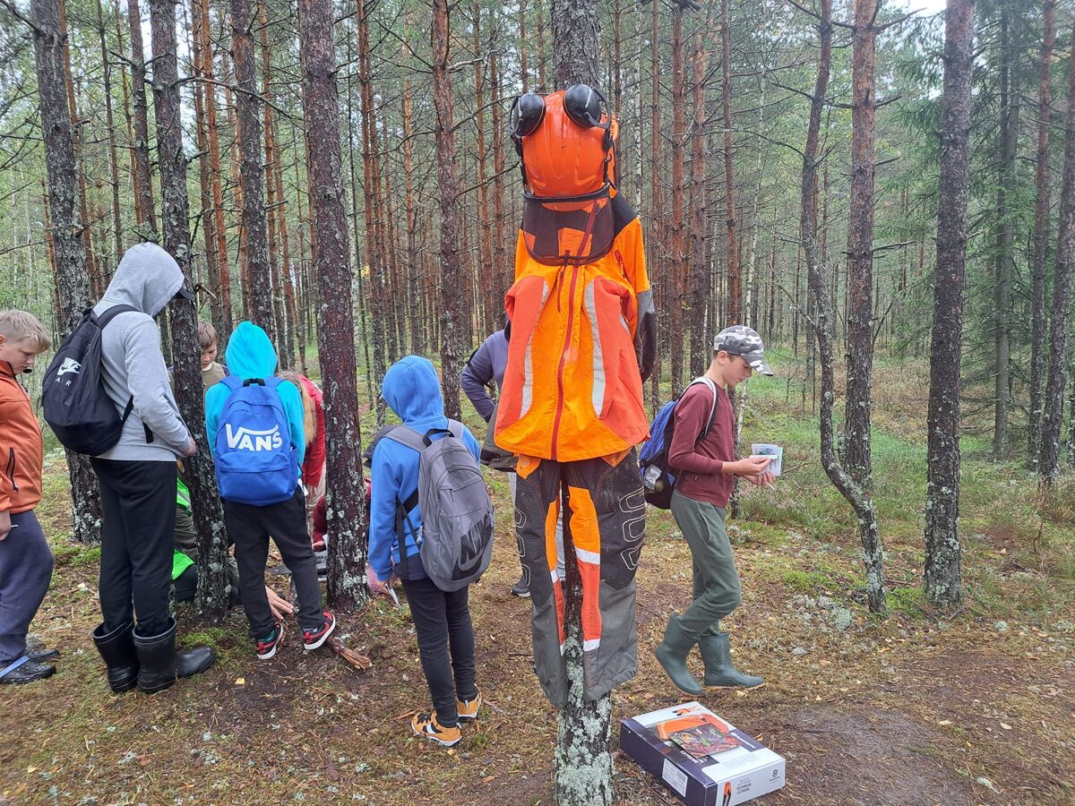 Skolēni veic uzdevumus mežā.